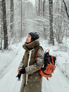 woman standing in snowy woods